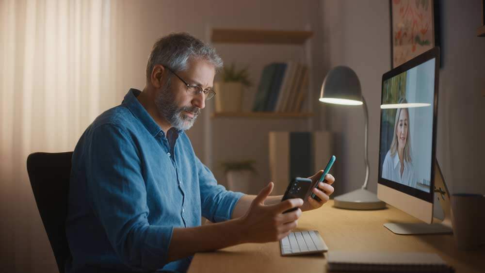 A cautious middle-aged man verifying his online match via video call