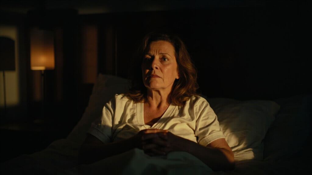 Middle-aged woman sitting up in bed unable to sleep at night