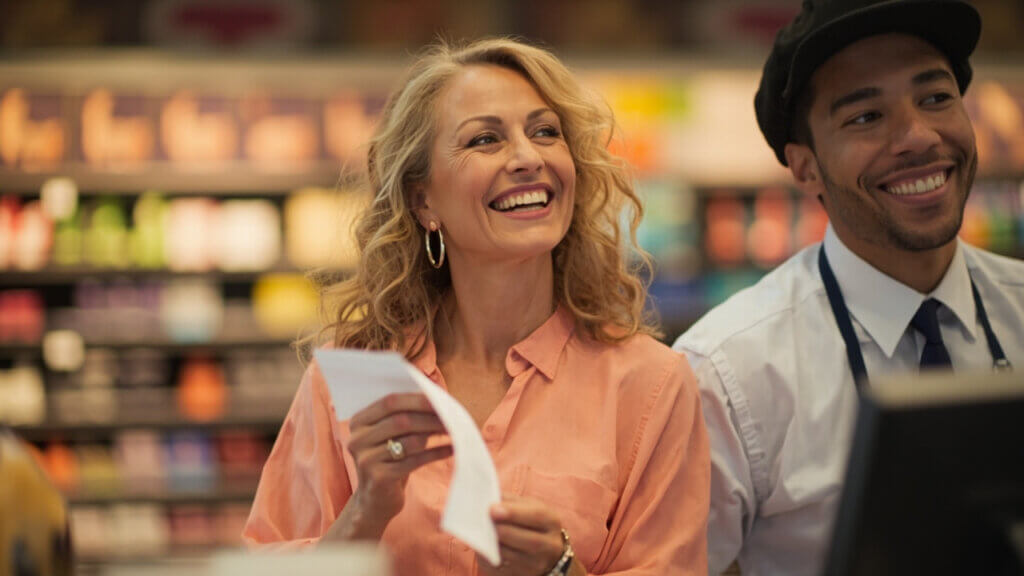 Smiling senior woman enjoying savings at checkout thanks to a senior discount